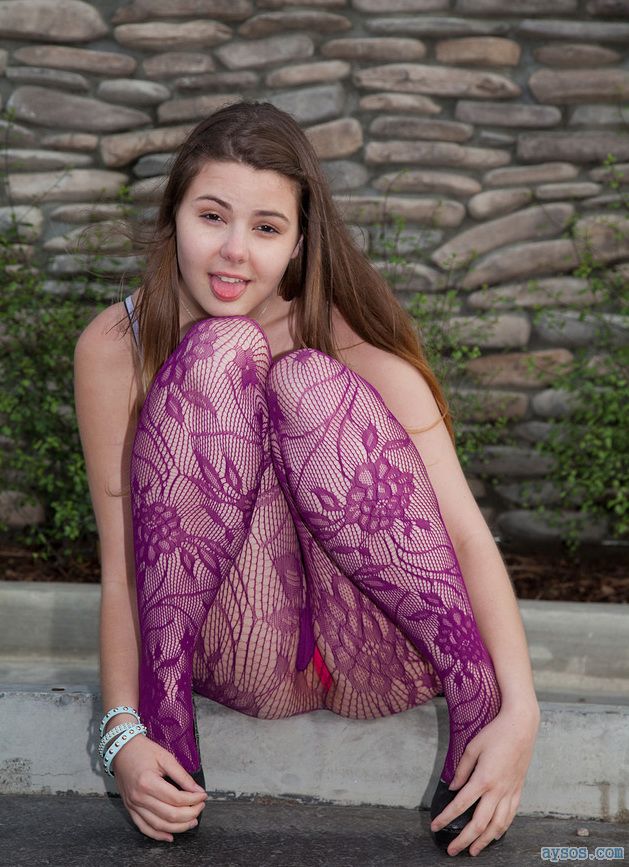 Slutty teen babe sticking out her tongue wearing very sexy purple pantyhose